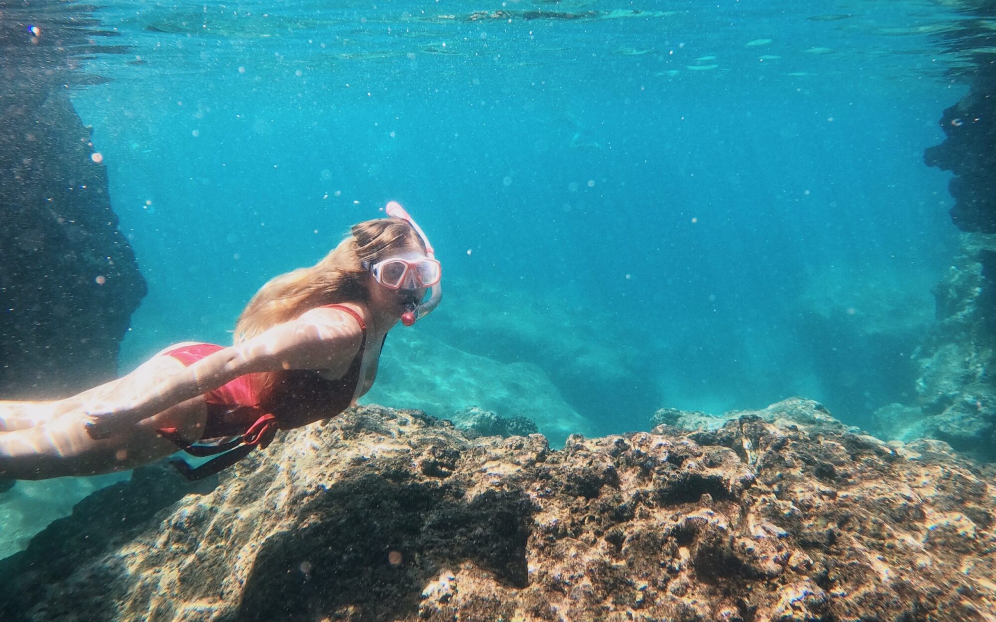 Woman snorkeling in turquoise blue waters in Oahu Hawaii